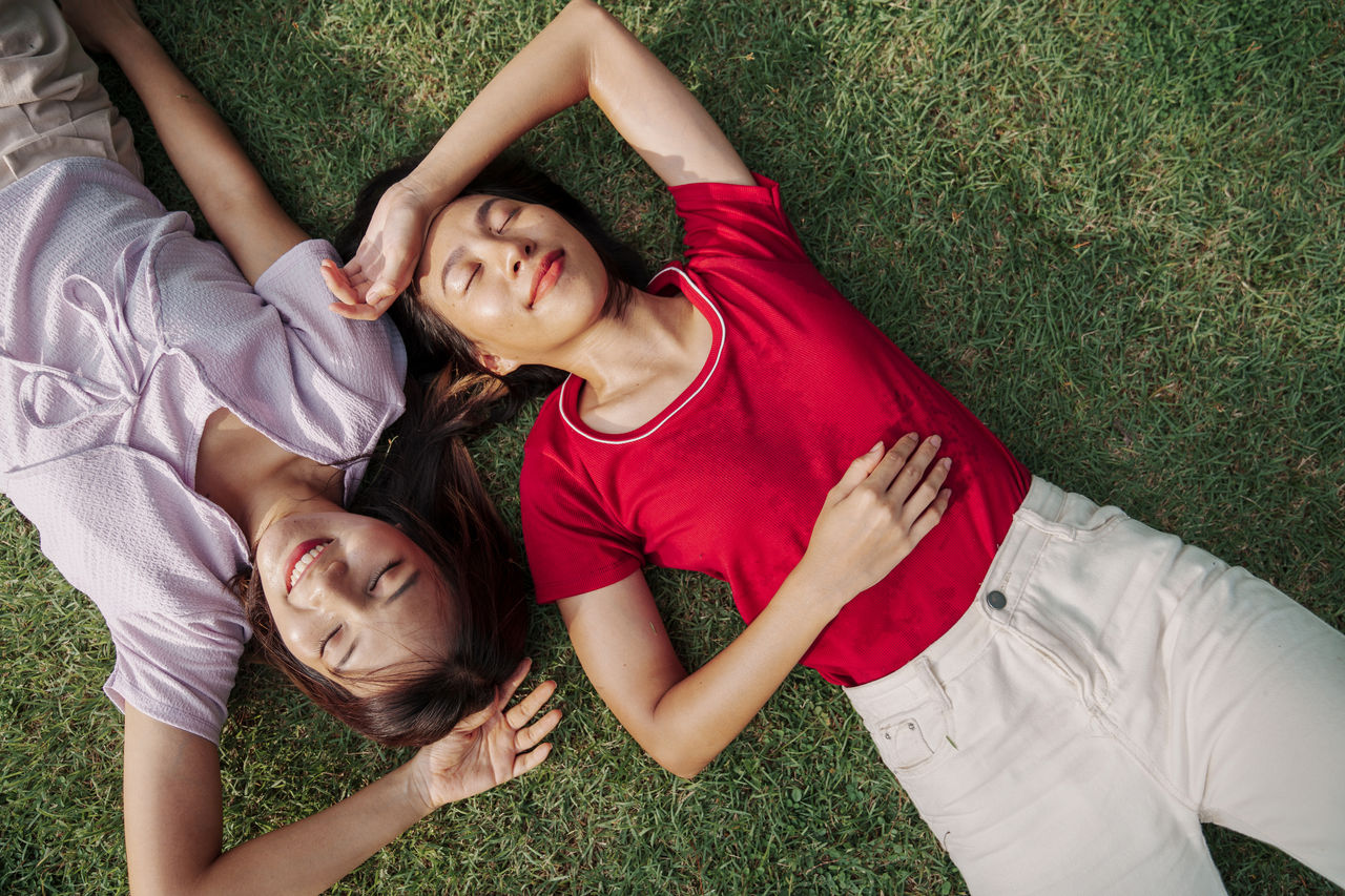 2 girls lay on grass with no worries