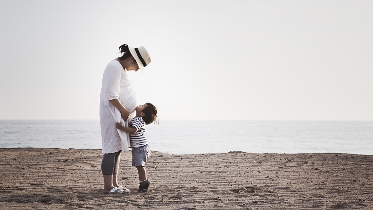 A daughter looking up at his mother at a beach