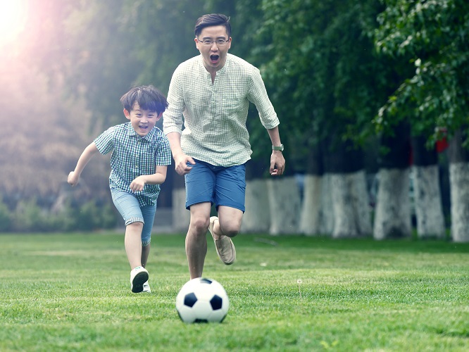 A father and his son playing soccer