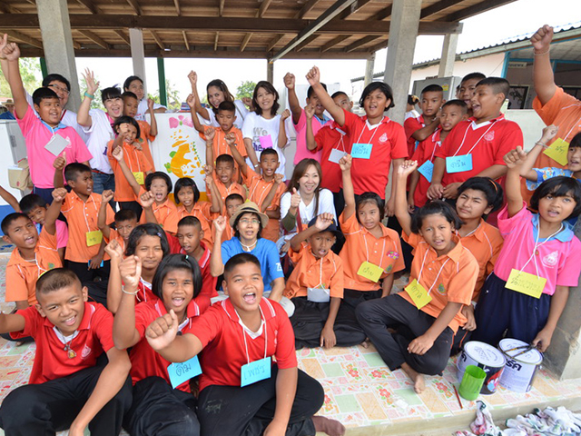 A group photo of volunteers and students cheering