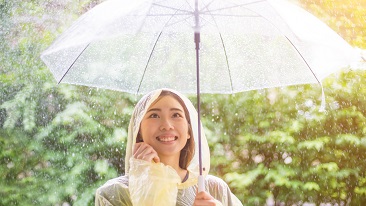 A lady in raincoat holding an umbrella