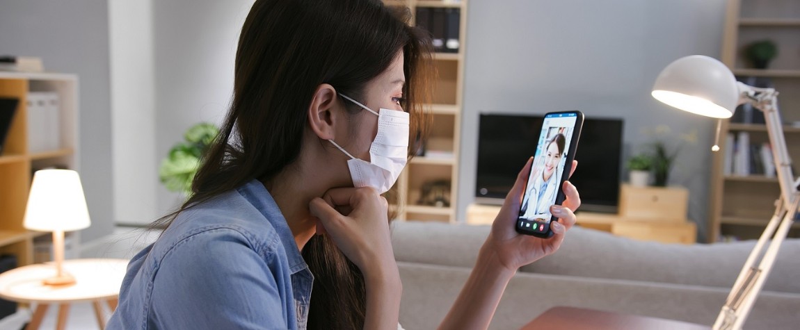 A lady with a face mask looking at her phone