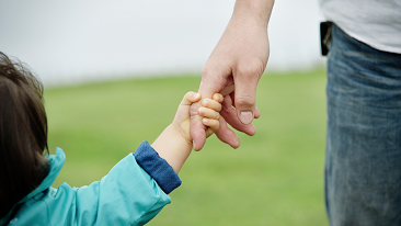 A boy holding his father’s hand
