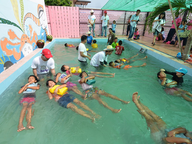 Volunteers teaching students how to swim