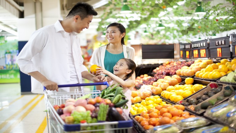 A family of three shopping for groceries