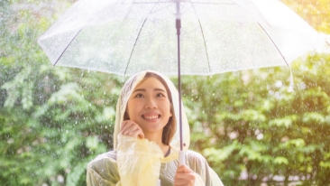 A lady in raincoat holding an umbrella