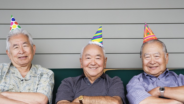 Three elderly men smiling to the camera